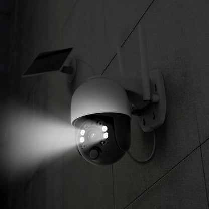 Witte Foscam B4 draadloze 4MP beveiligingscamera met spotlight en zonnepaneel gemonteerd aan een grijze buitenmuur.
